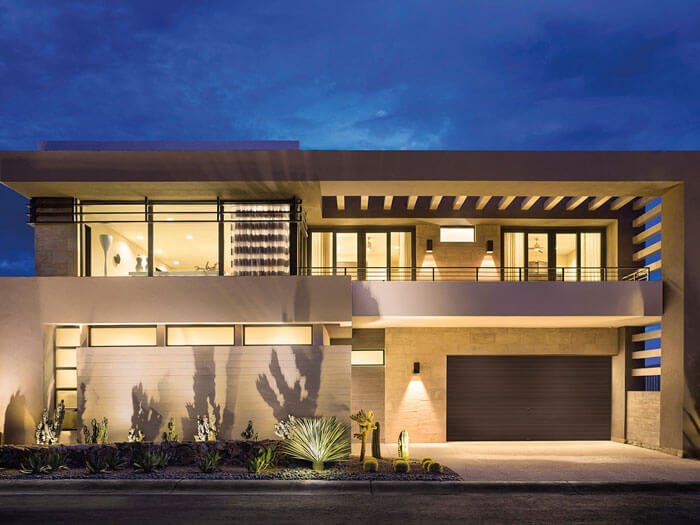 Modern two-story house with large windows at dusk.