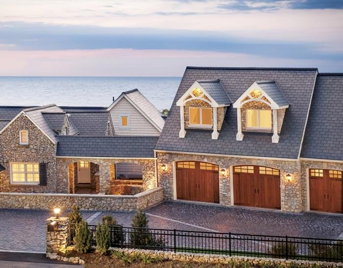 Stone house with three-car garage near the water.